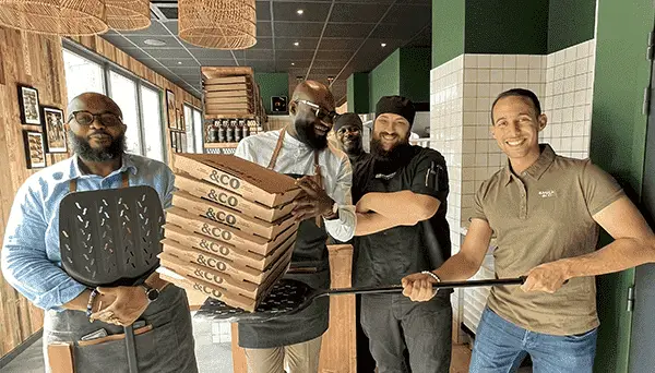 De gauche à droite, Thibaut Hamel, Cédric Hoffer, un équipier du restaurant et deux membres de l'équipe Basilic & Co dans le restaurant de Chatenay Malabry. Cédric tient une pile de boites à pizzas.